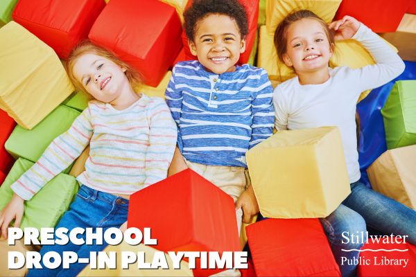 Three children laying on soft, multi-colored blocks