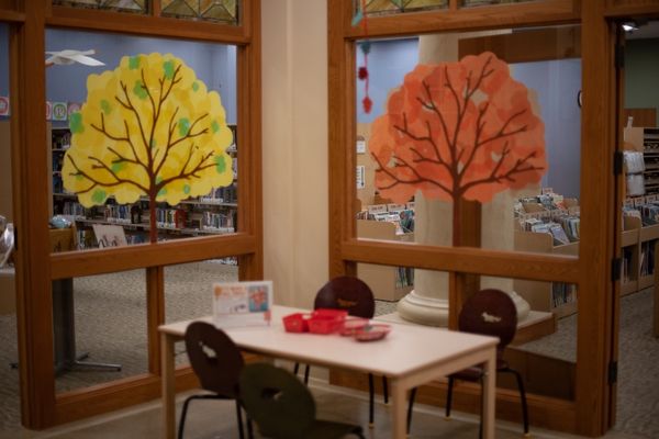 Discovery Room with interior windows painted with fall trees and a small table for children