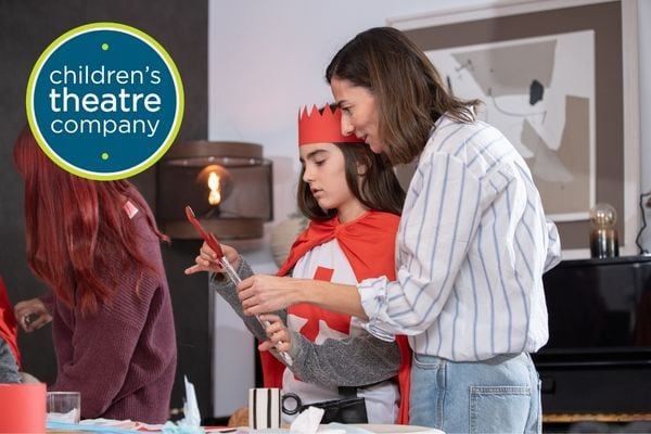 Adult and child working together to create a tinfoil-covered sword