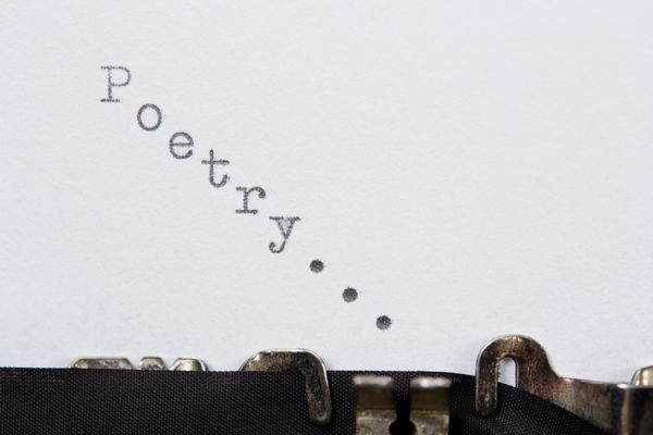 sheet of paper in typewriter with letters splleing "poetry..."